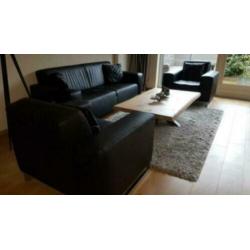 Twee zwarte PU-leder fauteuils en 1 bank in zwart PU-leder